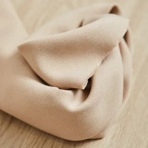 Tela de color beige arena Canvas Tencel Lyocell marca meetMILK, detalle de trama visible tipo loneta y pliegues suaves