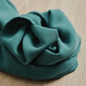 Tela de color verde esmeralda oscuro Canvas Tencel Lyocell de meetMILK, detalle de la textura rugosa suave y pliegues con caída pesada.