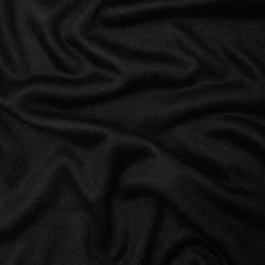 Tela de Punto Soft Lima Knit en color negro profundo, dispuesta en pliegues suaves para mostrar su textura elegante y caída pesada.