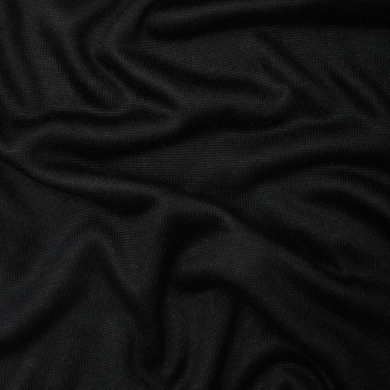 Tela de Punto Soft Lima Knit en color negro profundo, dispuesta en pliegues suaves para mostrar su textura elegante y caída pesada.