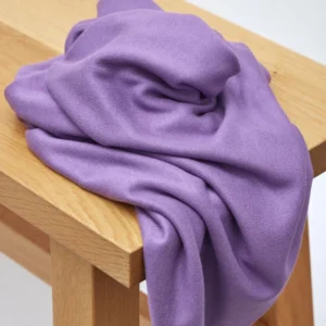 Tela de Punto Soft Lima Knit de meetMILK en un delicado color malva, dispuesta en pliegues suaves para mostrar su textura elegante y caída pesada.