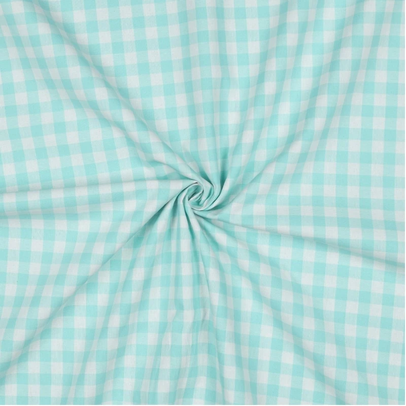Primer plano de la tela vichy menta mostrando la suave trama del algodón y el detalle del cuadro de 1 cm junto a una cinta métrica de costura.