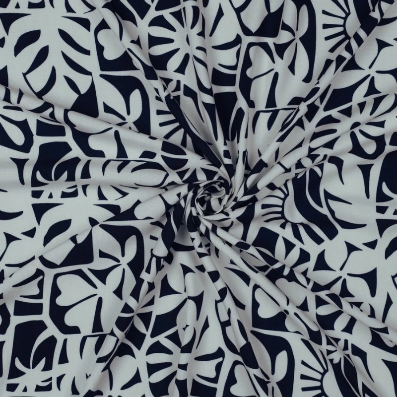 tela de viscosa estampada azul marino y blanca, recogida y drapeada para mostrar su extrema ligereza, su fluidez y su impecable caída.